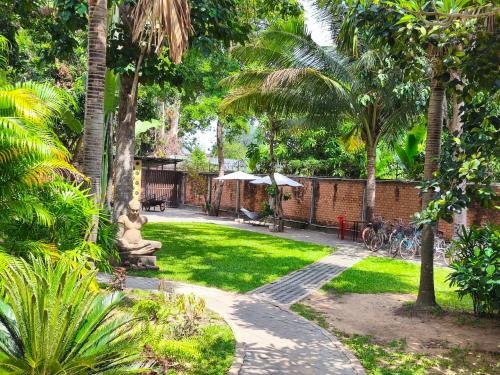 a garden with a statue in the middle of a yard at Sala Baï Hotel & Restaurant School in Siem Reap