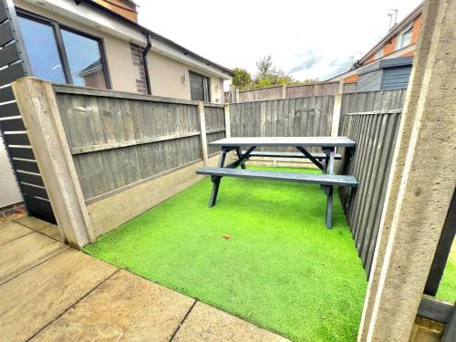a picnic table sitting on the grass next to a fence at Yastayzzz at Studio 3 Bransford Road in Worcester