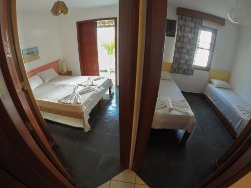 a room with two beds and a couch in it at DAPRAIA - APART TAPERAPUAN PRAIA VILLAGE in Porto Seguro