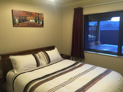Schlafzimmer mit einem Bett und einem Fenster in der Unterkunft Lawrence Townhouse Accommodation 18A in Lawrence