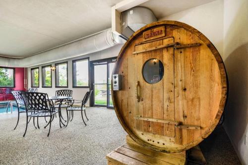 a large wooden barrel in a room with a table and chairs at Super 8 by Wyndham Eveleth in Eveleth