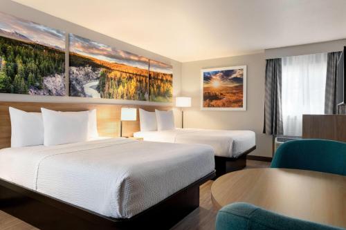 a hotel room with two beds and a table at Days Inn by Wyndham Worland in Worland