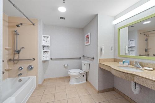 a bathroom with a toilet and a tub and a sink at Hampton Inn & Suites Madera in Madera