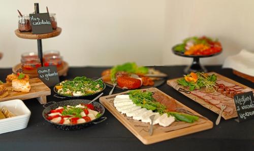 a table topped with different types of food on cutting boards at Pokoje gościnne Restauracja u Kusia in Mikołów