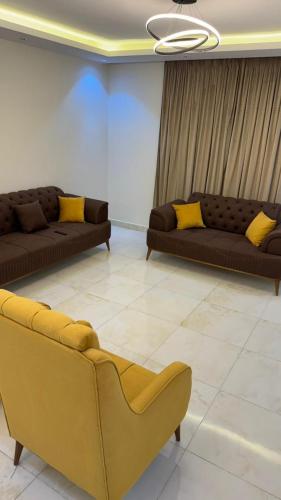 two couches in a living room with yellow pillows at أوشان للشقق المفروشة in New cairo