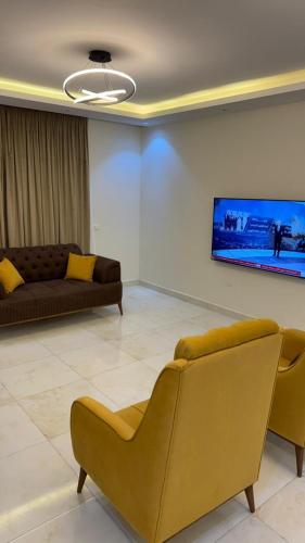 a living room with a couch and a tv on the wall at أوشان للشقق المفروشة in New cairo