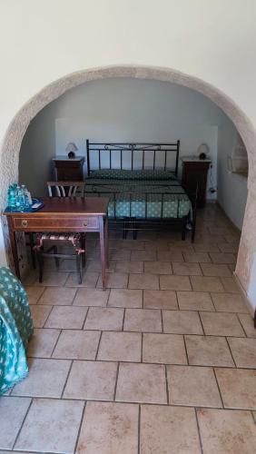 a room with a bed and a table in a room at Tenuta Antico Leccio in Gioia del Colle