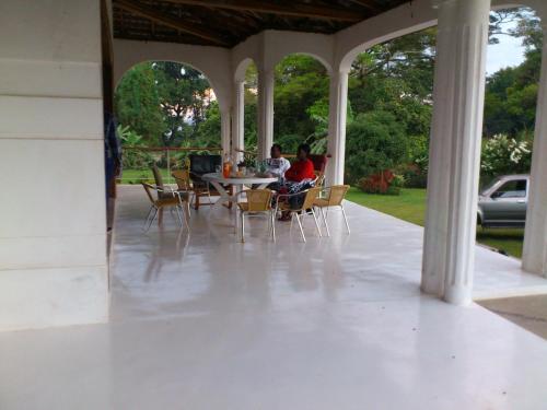 duas pessoas sentadas numa mesa num alpendre em Egg Botanical View em Entebbe