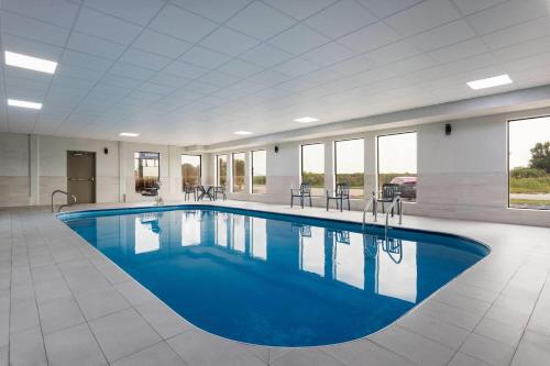 a large pool with blue water in a building at Days Inn and Suites by Wyndham Hammond, IN in Hammond