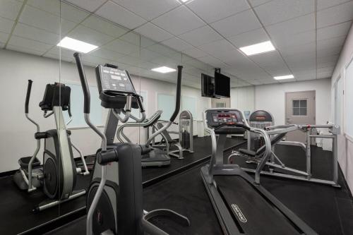 a gym with several treadmills and cardio machines at Days Inn and Suites by Wyndham Hammond, IN in Hammond