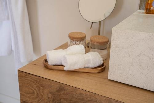 two towels on a wooden tray on a table at Ferme La Clavière, Suite de Luxe Lou Estello in Mane