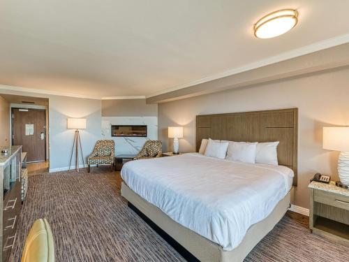a hotel room with a large bed and a desk at Amanzi Hotel, an Ascend Collection Hotel in Ventura