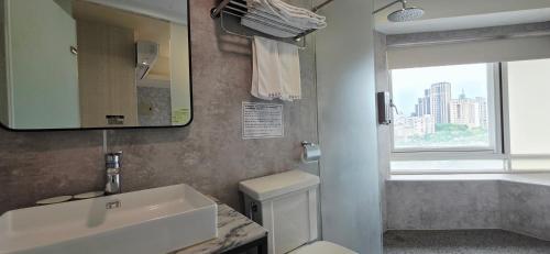 a bathroom with a sink and a toilet and a window at 慶爾喜旅館西門捷運館Gugis Inn in Taipei