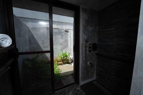 a bathroom with a glass door leading to a patio at Wild Origin Kabini - A Luxury Resort in Kabini River