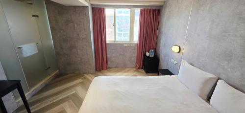 a bedroom with a white bed and a window at 慶爾喜旅館西門捷運館Gugis Inn in Taipei