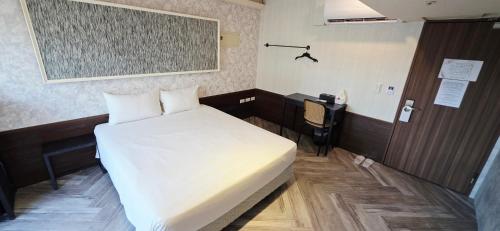 a room with a bed and a desk and a phone at 慶爾喜旅館西門捷運館Gugis Inn in Taipei