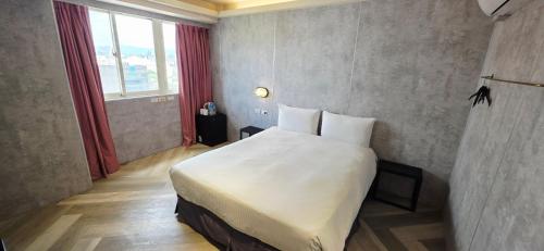 a bedroom with a large white bed and a window at 慶爾喜旅館西門捷運館Gugis Inn in Taipei