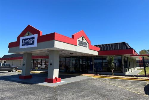 a convenience store with a red and white building at Travelodge by Wyndham Lumberton in Lumberton