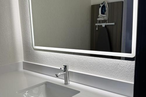 a bathroom sink with a large mirror above it at Travelodge by Wyndham Lumberton in Lumberton