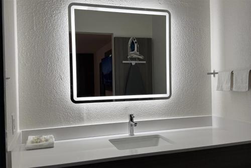 a bathroom with a sink and a mirror at Travelodge by Wyndham Lumberton in Lumberton