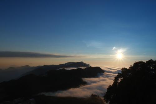 a view of the sun rising over the clouds and mountains at Siangting B&B in Fenchihu
