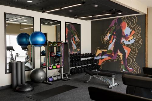 a gym with dumbbells and a painting on the wall at LivSmart Studios By Hilton Tullahoma in Tullahoma