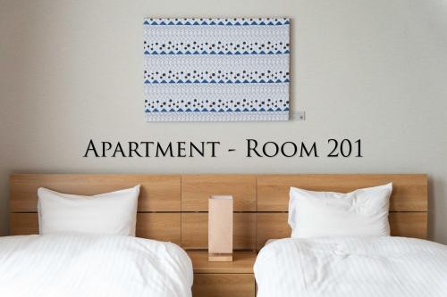a sign that reads apartment room above two beds at Ginkgo House ギンコハウス in Fujiyoshida