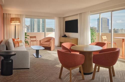 a living room with a couch and a table and chairs at The Ambassador of Waikiki, Tapestry Collection by Hilton in Honolulu