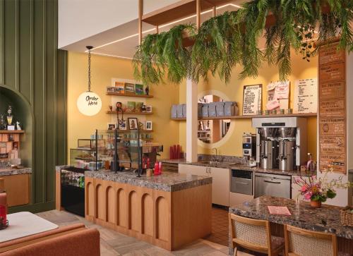 a coffee shop with a counter and tables and chairs at The Ambassador of Waikiki, Tapestry Collection by Hilton in Honolulu
