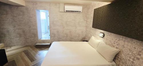 a bedroom with a white bed with a window at 慶爾喜旅館西門捷運館Gugis Inn in Taipei