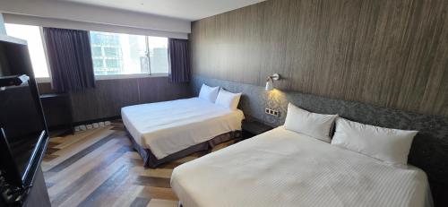 a hotel room with two beds and two windows at 慶爾喜旅館西門捷運館Gugis Inn in Taipei