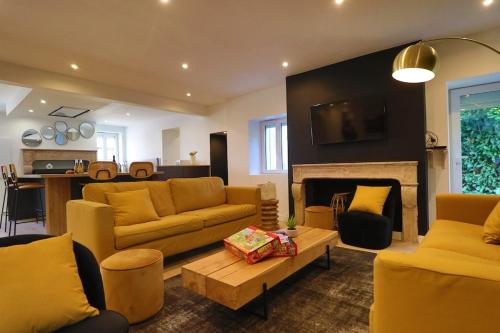 ein Wohnzimmer mit gelben Möbeln und einem Kamin in der Unterkunft Domaine en bord de saone in Pagny-le-Château