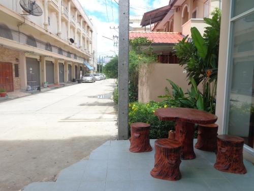 a wooden table and stools next to a street at A&S Residence Kanchanaburi in Kanchanaburi City