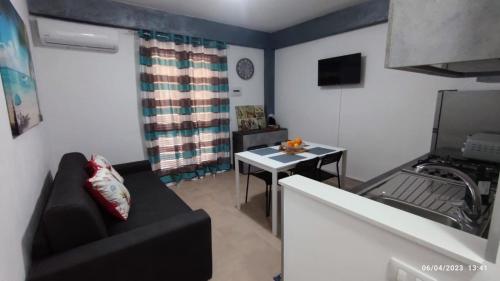 a living room with a couch and a table at Capo D'Argento Home in SantʼAlessio Siculo