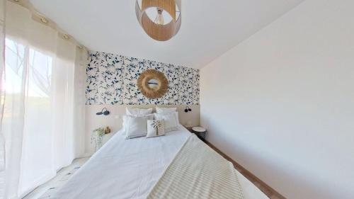 a bedroom with a white bed with a wreath on the wall at Le Cocon d'Andernos Rooftop et Sea View in Andernos-les-Bains