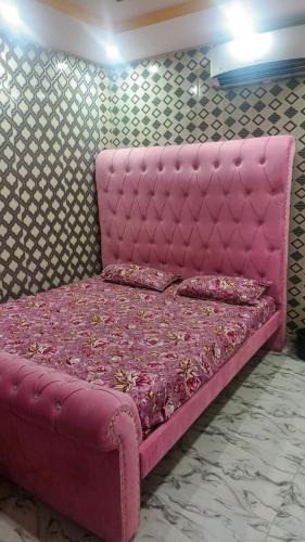 a pink bed with pillows on it in a room at Lakshmi Hotel Lahore in Lahore