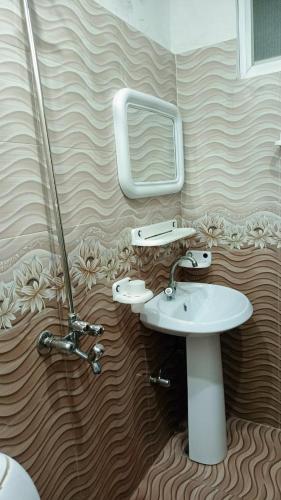 a bathroom with a sink and a mirror at Lakshmi Hotel Lahore in Lahore