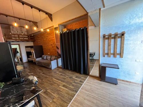 Una sala de estar con una cortina negra en una habitación. en Стадия лофт 2, en Chornomorsk