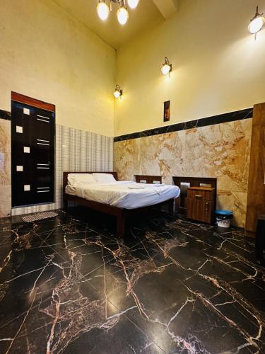 a bedroom with a bed and a stone wall at Deep Rich Farm villa Munnar in Anachal