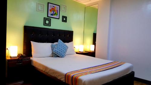 a bedroom with a bed with two pillows and two lamps at 950 Condotel in Angeles