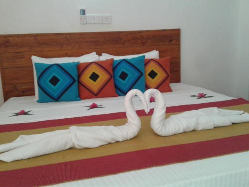 two swans made out of towels on a bed at Wild Hut Habarana in Habarana