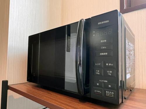 a microwave oven sitting on a wooden shelf at ステラサイト函館 in Hakodate