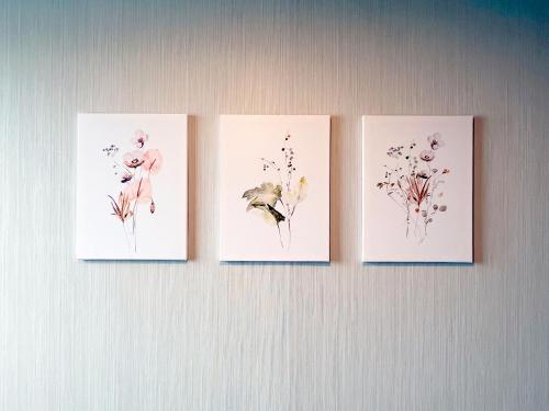 four paintings of flowers on a wall at ステラサイト函館 in Hakodate