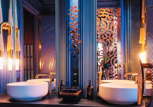 a bathroom with two sinks and two mirrors at Oasis Premium апартаменты возле Триумфальной арки in Astana