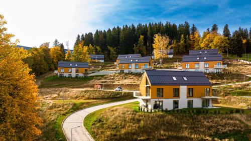 a group of houses on a hill with a road at Wonder Home - Domki Hillside tuż przy stoku narciarskim - na terenie kompleksu plac zabaw i zewnętrzna siłownia, sklep, parking in Karpacz