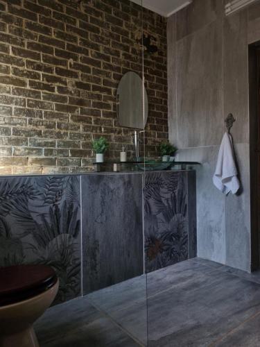 a bathroom with a sink and a brick wall at La Mouna 4 in Bultfontein in Bultfontein