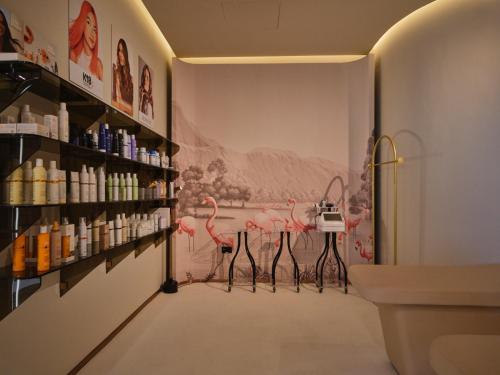 a room with a pharmacy with pink flamingos on the wall at The Muse in Doha