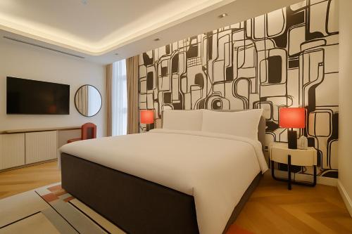 a bedroom with a large white bed and a wall mural at The Muse in Doha