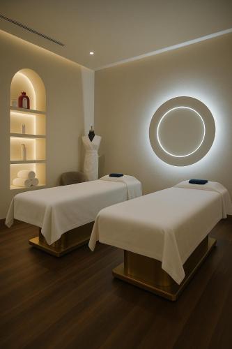 a room with two beds and a mirror on the wall at The Muse in Doha
