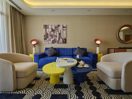 a living room with a blue couch and a table at The Muse in Doha